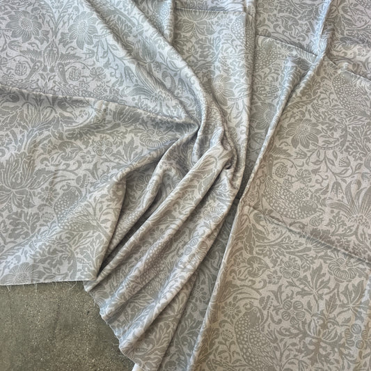 Cotton fabric with a soft damask style print shown in natural beige colour- ideal for dresses and tops