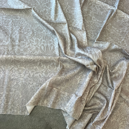 Cotton fabric with a soft damask style print shown in natural beige colour- ideal for dresses and tops